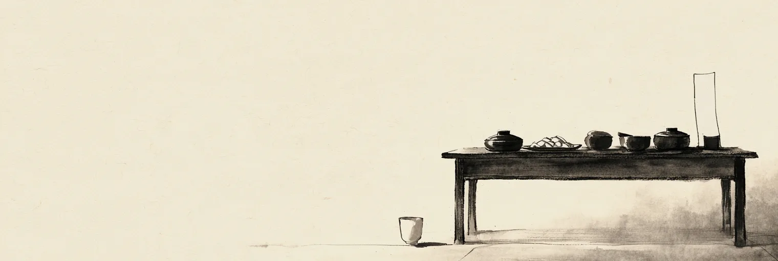 Korean ink-wash painting on aged hanji paper of a plain wooden table set with a few simple covered bowls and a small dish of half-moon rice cakes, a single small white cup set on the floor in front of it and a narrow blank slip of white paper standing upright at the back of the table, in soft morning light, placed in the right third of the paper and the left two thirds left empty, no people, no candles, no incense smoke